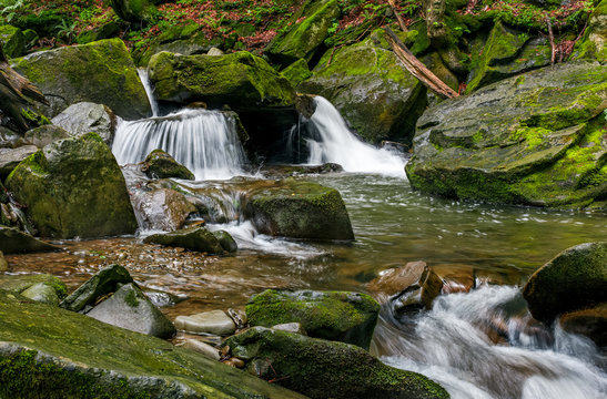 small cascade on the river among bouders in forest