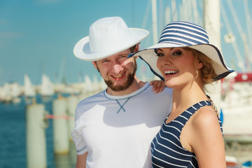 Tourist couple in marina against yachts in port