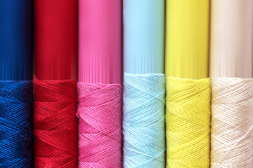 Close up multi color of the bobbins threads roll as background