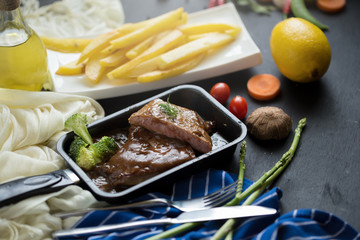 Fresh grilled meat. Grilled beef steak In the pan, French fries and Mashed potato with spoon, in serving bowl