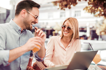 Couple working on laptop in cafe.