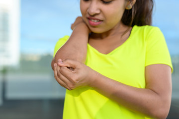 Young woman holding painful elbow