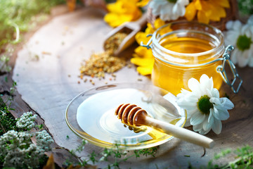 Delicious honey and fresh pollen of flowers on a wooden table. Selective focus.