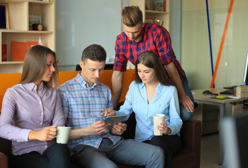 Smiling business people using tablet in office.