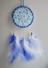 Photo of handmade dreamcatcher with feathers and beads on a white background