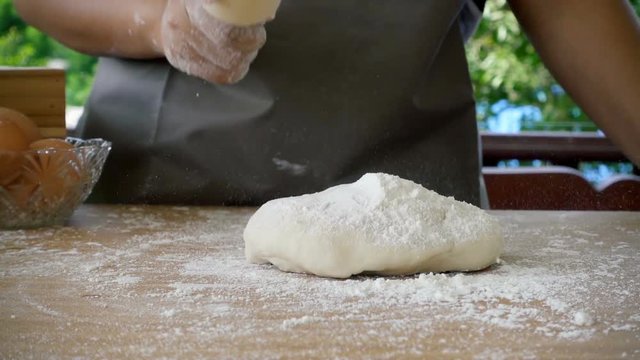 Female baker prepares fresh breads in slow motion