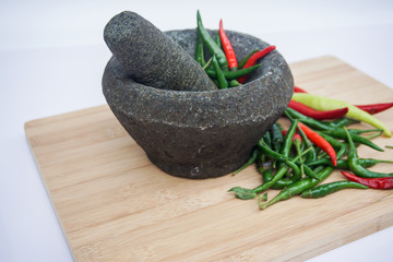 Red and green pepper in a stone mortar.