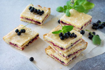 Homemade cookies with black currant berries on a gray stone or slate background. Summer pastries.