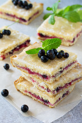 Homemade cookies with black currant berries on a gray stone or slate background. Summer pastries.