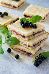 Homemade cookies with black currant berries on a gray stone or slate background. Summer pastries. Copy space.