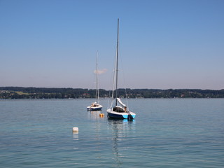 Fototapeta na wymiar Two Sailing Boats on Blue Lake with Mountain Background