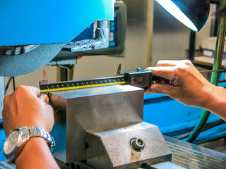 Technicians use digital counters to measure iron work from grinding. For precise quality control.