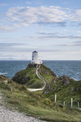 Fototapeta na wymiar Stunning Summer landscape image of lighthouse on end of headland with beautiful sky