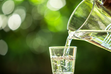 Glass of water on nature background.