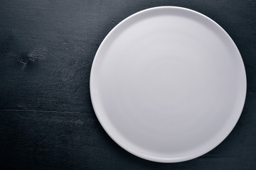 Plate. On a wooden background. Top view. Free space for your text.