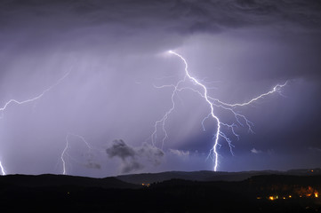 Lightning strike in a distant thunderstorm cloud of the cliffs (Dôme, Dordogne, France)