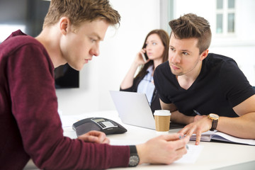 Obraz premium Businessmen Communicating While Colleague Using Smart Phone