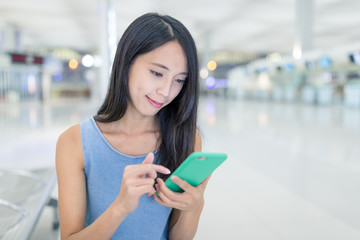 Fototapeta na wymiar Woman use of mobile phone in Hong Kong airport