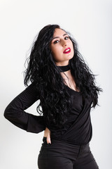 young turkish brunette woman wearing in black clothes poses on white background in studio