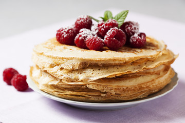 Stack of Russian-style pancakes with raspberries