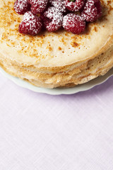 Stack of Russian-style pancakes with raspberries