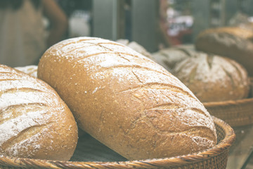 Fresh homemade bread placed on a wooden basket in the shopping mall italian bakery. Bali island, Indonesia.