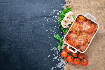 Lasagna with vegetables and cheese. On a wooden background. Top view. Free space for your text. - obrazy, fototapety, plakaty