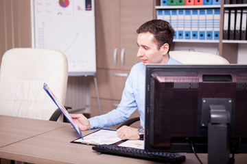 Young businessman in office analyzing charts. Business and investment
