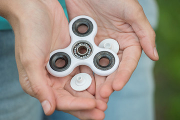 Broken details of a white spinner in the hands