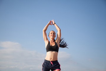 Obraz na płótnie Canvas Sports girl is engaged in fitness on the beach