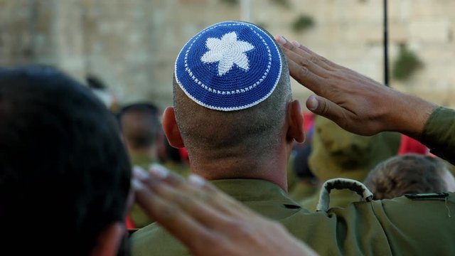 Israeli soldier military man saluting to the Western wall in Jerusalem. Western wall or Wailing wall or Kotel is the most sacred place for all jewish people.
