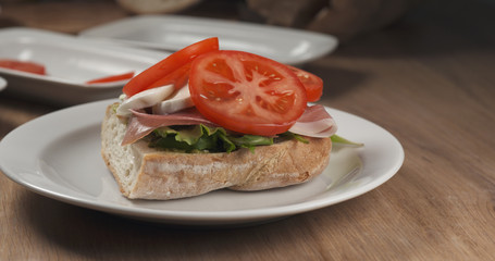 making italian sandwich with speck and mozzarella apply tomato