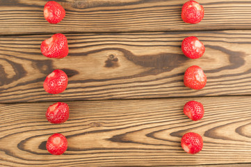 Two row of strawberries on old wooden background