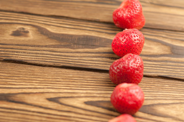 Row of fresh strawberry on old wooden planks