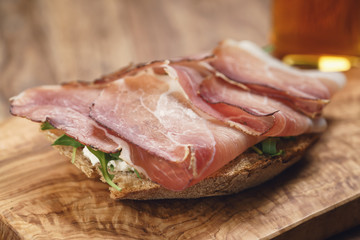 italian sandwich with speck, arugula salad and beer