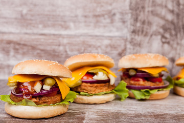 Burgers on wooden plate. Fast food. Unhealthy snack
