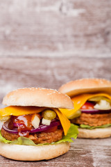Gourmet burgers on wooden plate. Fast food. Unhealthy snack