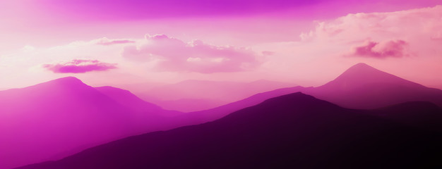 Fairytale panorama of mountain ranges in the twilight and clouds, pastel colors