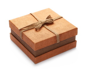 Closed golden gift box with string ribbon bow isolated on white background