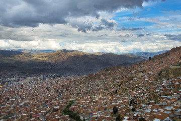 The city of La Paz seen from El Alto and the surrounding mountains on the background, in Bolivia,...