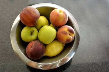 Una vasa de frutas.. manzana, melocoton, limon