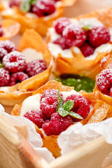 Phyllo cups with Mascarpone cheese filling topped with fresh Raspberries and mint, delicious dessert 