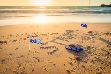 Straya text, flag and thongs on beach