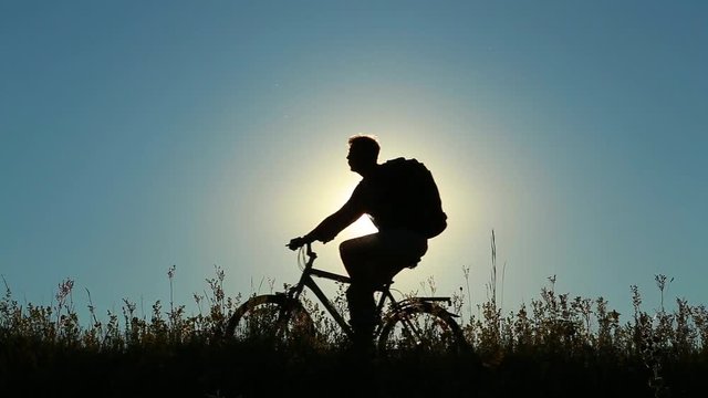 Family of three people having ride together in rural landscape. Son, mother and father riding bikes over sunset blue sky background. Family bikers having fun on vacations. Real time full hd video.