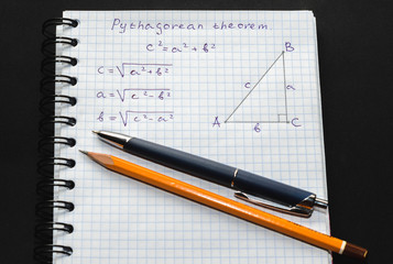 Page with formulas and the Pythagorean theorem with pen and pencil