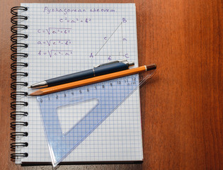 Page with formulas and the Pythagorean theorem with pen and pencil