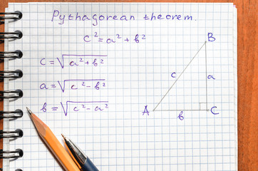 Page with formulas and the Pythagorean theorem with pen and pencil