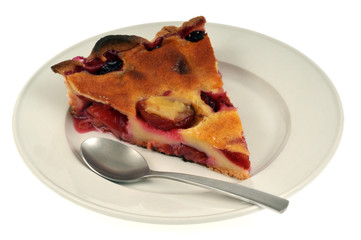 Tarte aux prunes dans une assiette sur fond blanc 