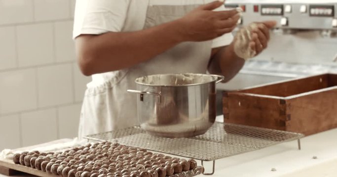 Chocolate master in his factory makes a truffles. Chocolate truffles making of process