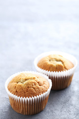 Tasty muffins on a grey wooden table